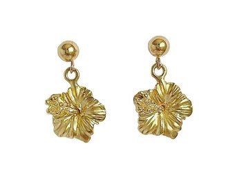 May include: A pair of gold-tone earrings featuring a delicate hibiscus flower design.