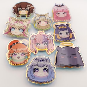 May include: A collection of nine holographic acrylic charms featuring anime-style character designs. The charms showcase various characters with distinct hairstyles, facial expressions, and accessories, including halos and cat ears. Each charm has a gold border.