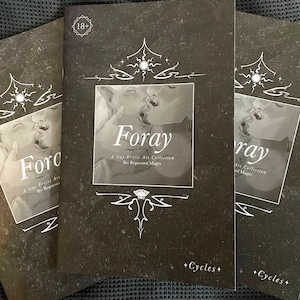 Peut inclure: Trois exemplaires d'un livre intitulé "Foray" avec une couverture noire et une image en niveaux de gris de deux personnes s'embrassant. Le livre est intitulé "A Gay Erotic Art Collection". La couverture comporte également des éléments décoratifs et le texte "+Cycles+".