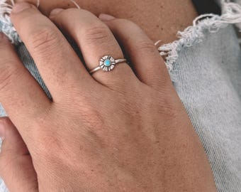 Conjunto de anéis empilháveis com flor pequena e turquesa em prata.