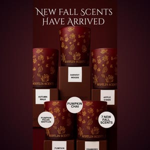 Puede incluir: Exhibición de candelabros de vidrio color burdeos con diseños de hojas doradas. El texto "NEW FALL SCENTS HAVE ARRIVED" está en la parte superior. La imagen también muestra los nombres de las fragancias: Harvest Woods, Autumn Walk, Pumpkin Chai, Apple Cider, Pumpkin Pecan Waffles y Cranberry.