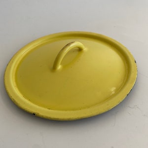 May include: Yellow enamel cast iron pot lid with a black handle.