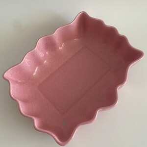 以下が含まれることがあります： 波打つ縁取りのあるピンクのセラミック製のベーキングディッシュ。ディッシュは斑点模様の仕上げになっています。