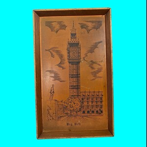May include: A wooden tray with a brown background and a black and white image of Big Ben, the famous clock tower in London, England. The image is surrounded by a brown wooden frame.
