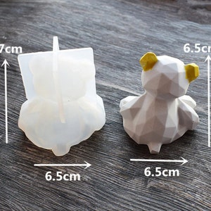 May include: A clear silicone bear mold and a finished geometric bear figurine. The mold is 7 cm tall and 6.5 cm wide. The finished bear is white with yellow ears and is 6.5 cm wide.