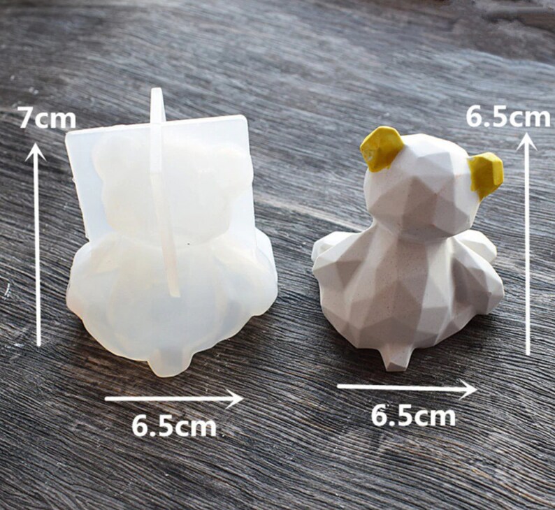 May include: A clear silicone bear mold and a finished geometric bear figurine. The mold is 7 cm tall and 6.5 cm wide. The finished bear is white with yellow ears and is 6.5 cm wide.