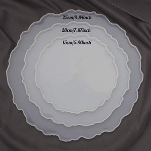 May include: Three white resin trays with a scalloped edge, in descending sizes. The largest tray is 25cm in diameter, the middle tray is 20cm, and the smallest is 15cm. The sizes are also given in inches: 9.84, 7.87, and 5.90.