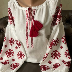 Light and delicate embroidered blouse on white linen in traditional colors.