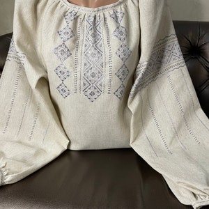 Women&#39;s blouse with silver hand embroidery. The style of hand embroidery is glad