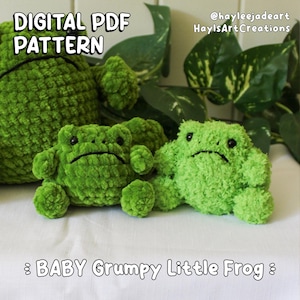 May include: A digital PDF pattern for crocheted "Baby Grumpy Little Frog" plushies. The image shows two small, green, plush frogs with a grumpy expression, and the text "DIGITAL PDF PATTERN" and "@hayleejadeart HaylsArtCreations".