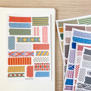 Op de afbeelding: Een vel met kleurrijk washi tape met verschillende patronen, waaronder stippen, strepen en geometrische patronen. De tape is in rijen op een witte achtergrond gerangschikt.