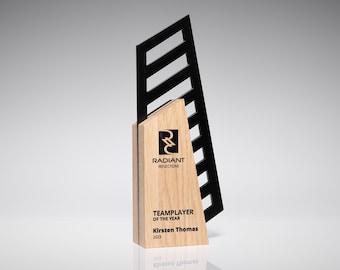 May include: A wooden award with a black accent. The award features the text "RADIANT REFLECTIONS TEAMPLAYER OF THE YEAR Kirsten Thomas 2023". The award has a geometric design.