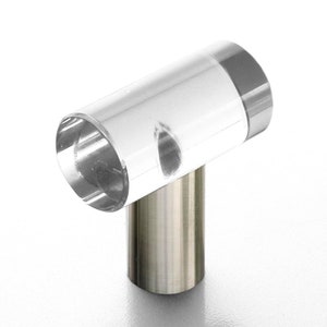 May include: A clear acrylic cabinet knob with a silver metal base. The knob is shaped like a T.