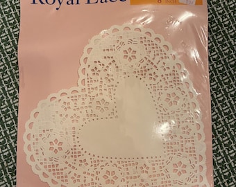 An unopened package of 12 eight inch heart shaped paper doilies.