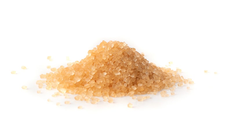May include: A close-up of a pile of light brown granulated sugar crystals.