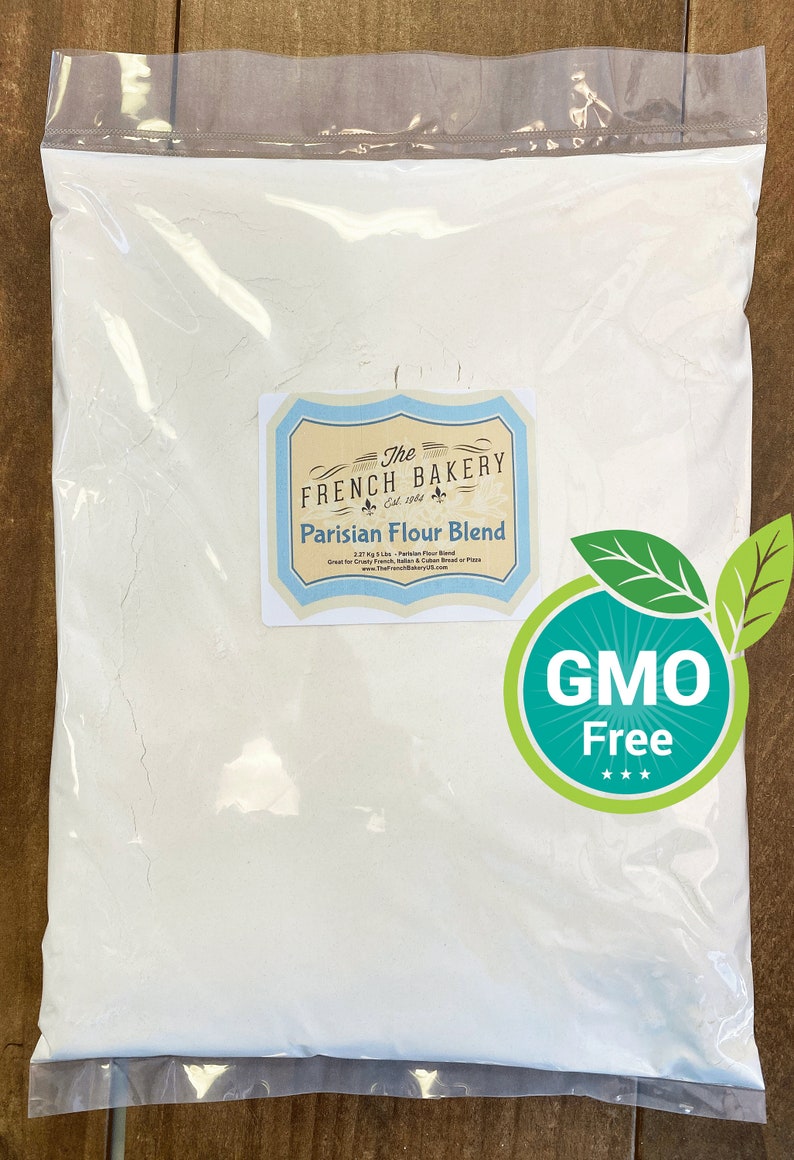 May include: A clear plastic bag filled with white Parisian Flour Blend. The label reads "The French Bakery" and "GMO Free". The bag contains 2.27 kg of flour, perfect for crusty French, Italian, and Cuban bread or pizza.