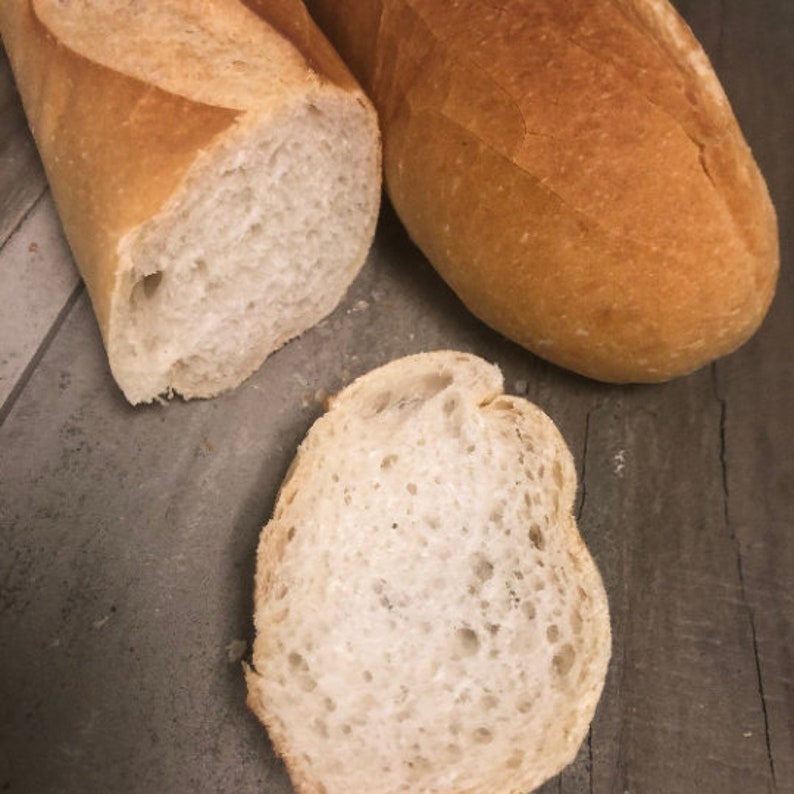 May include: A close-up of three slices of white bread. The bread is soft and fluffy, with a light brown crust.