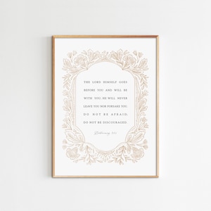 Puede incluir: Una impresión enmarcada con fondo blanco y texto dorado y borde floral. El texto dice: "EL SEÑOR MISMO VA DELANTE DE TI Y ESTARÁ CONTIGO; NUNCA TE DEJARÁ NI TE ABANDONARÁ. NO TENGAS MIEDO; NO TE DESANIMES." Deuteronomio 31:8.