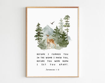 May include: A watercolor print with a deer in a forest setting. The print features a mountain, trees, and a bird flying overhead. The text reads "Before I formed you in the womb I knew you, before you were born I set you apart. Jeremiah 1:5"
