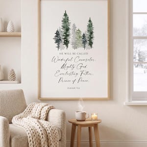 Può includere: Una stampa artistica da parete incorniciata con un'illustrazione ad acquerello di pini verdi sopra il testo: HE WILL BE CALLED Wonderful Counselor. Mighty God. Everlasting Father. Prince of Peace. ISAIAH 9:6 in carattere nero serif e corsivo.