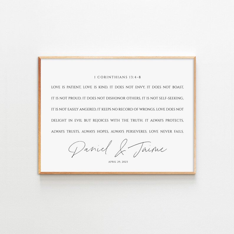 May include: A framed print with a white background and black text. The text is a quote from the Bible, 1 Corinthians 13:4-8, about love. The print also includes the names "Daniel & Jaime" and the date "April 29, 2023".