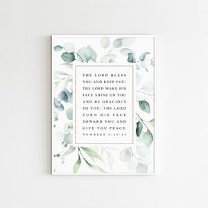 May include: A watercolor print with a white background and green eucalyptus leaves. The print features a gold frame with the text "THE LORD BLESS YOU AND KEEP YOU; THE LORD MAKE HIS FACE SHINE ON YOU AND BE GRACIOUS TO YOU; THE LORD TURN HIS FACE TOWARD YOU AND GIVE YOU PEACE. NUMBERS 6:24-26"