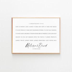 May include: A printable wedding sign with a white background and a brown frame. The sign features a quote from the Bible, 1 Corinthians 13:4-8, about love. The quote is in black text and the names "Melissa & David" are written in cursive script below the quote. The date "October 28 2018" is written in black text below the names.