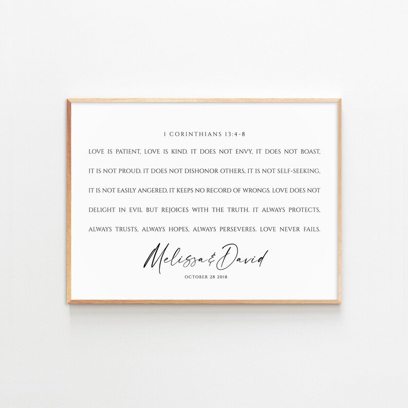 May include: A printable wedding sign with a white background and a brown frame. The sign features a quote from the Bible, 1 Corinthians 13:4-8, about love. The quote is in black text and the names "Melissa & David" are written in cursive script below the quote. The date "October 28 2018" is written in black text below the names.