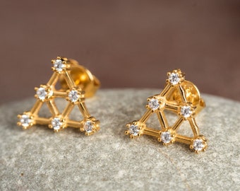 Puede incluir: Un par de pendientes triangulares de oro con pequeñas piedras de circonita cúbica transparentes.