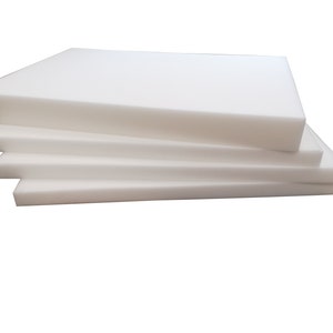 May include: A stack of four white foam sheets, each rectangular and of varying thicknesses. The foam appears clean and smooth, with a bright, neutral color. The sheets are neatly arranged, suggesting a product for padding or insulation.