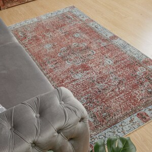 May include: A vintage-style rug with a faded red and blue pattern. The rug has a distressed look and is perfect for adding a touch of bohemian style to any room.
