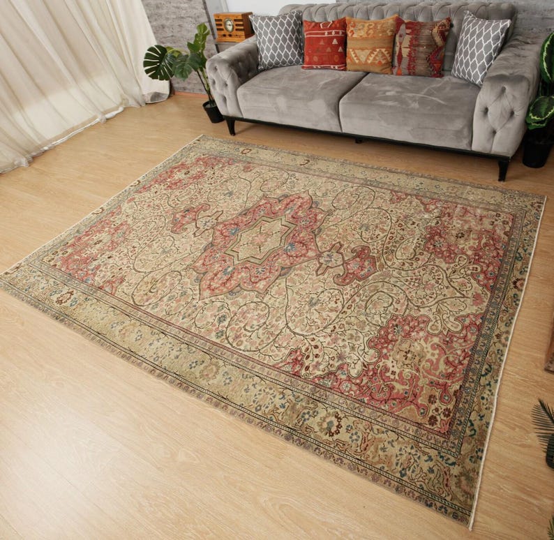 Pu&ograve; includere: Un grande tappeto rettangolare con un design tradizionale e intricato. Il tappeto presenta un medaglione centrale nei toni del rosso e del beige, circondato da motivi floreali e a vite. Il bordo &egrave; beige scuro con un motivo dettagliato.