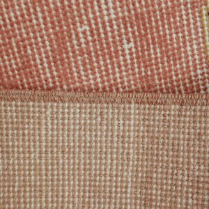 May include: Close-up of a rug with a pink and white patterned top and a beige bottom. The rug has a woven texture.