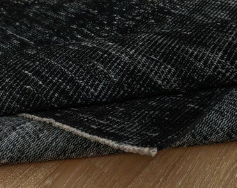 Pode incluir: Close-up de um tapete com padrão preto e branco. O tapete está dobrado ao meio, mostrando a textura do tecido.