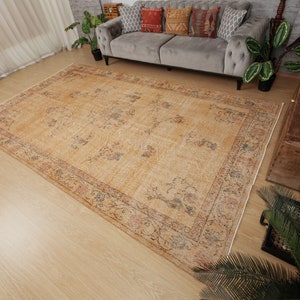May include: A vintage-style rug with a beige background and a floral pattern in shades of brown, red, and blue. The rug has a faded, distressed look, giving it a unique and antique feel.