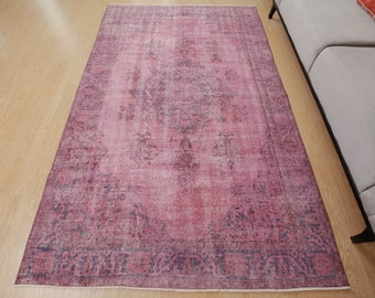 May include: A vintage pink and blue rug with a faded floral pattern. The rug has a distressed look and is perfect for adding a touch of bohemian style to any room.