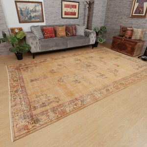 May include: A vintage-style rug with a beige background and a multi-colored floral pattern. The rug has a faded look and is made of wool.
