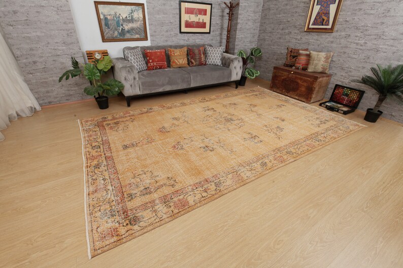 May include: A vintage-style rug with a beige background and a multi-colored floral pattern. The rug has a faded look and is made of wool.