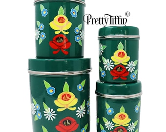 May include: Set of four green metal canisters with floral designs. Each canister features a different floral pattern with red, yellow, and white flowers. The canisters are stacked on top of each other.