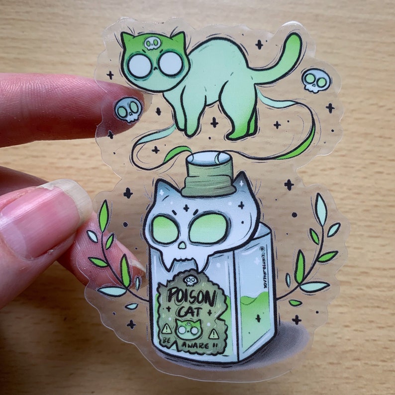 Peut inclure: Un chat vert avec un cr&acirc;ne sur la t&ecirc;te flotte au-dessus d'une bouteille en verre avec un bouchon en forme de cr&acirc;ne. La bouteille est remplie d'un liquide vert et porte une &eacute;tiquette qui indique "Poison Cat Be Aware!!".