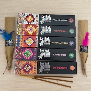 May include: Five boxes of incense sticks with colourful patterned designs. The boxes are stacked vertically and labelled with the scents: Frankincense, Cinnamon, Sandalwood, Lavender, and Myrrh. The boxes are all black with white text and a tribal-inspired logo.
