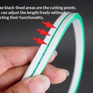 May include: A flexible, white and green LED strip with black lines indicating cutting points. The text states that the length can be adjusted without affecting functionality. The strip is shown against a dark background.