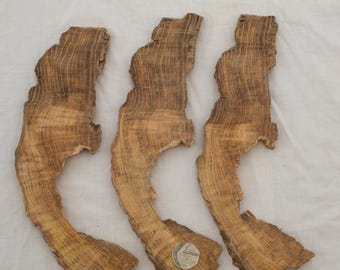 May include: Three pieces of oak wood, each measuring 28 cm by 8 cm by 1.3 cm. The wood has a natural, brown colour and a unique grain pattern. Lot 5.