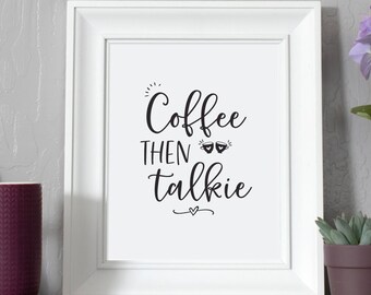 May include: White framed print with the text "Coffee then talkie" in black cursive font. The print is on a shelf with a purple mug, a white wooden letter A, a small potted succulent, and a potted purple flower.
