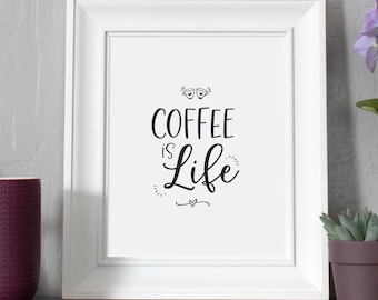 Könnte beinhalten: Ein weißer Bilderrahmen mit dem Text "Coffee is Life" in schwarzer Schrift. Eine lila Tasse, ein Holzbuchstabe A, eine kleine Sukkulente im Topf und ein lilafarbener Hortensientopf stehen auf einem grauen Regal.