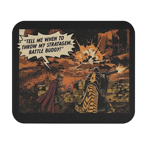 May include: A black square coaster featuring a comic book-style illustration of a battlefield scene. The image shows two soldiers, one with a red cape, and the other firing a weapon. Text in a speech bubble reads, "TELL ME WHEN TO THROW MY STRATAGEM, BATTLE BUDDY!"
