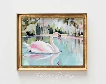 May include: A framed painting of a white swan with pink accents swimming in a blue and green lake. The background features a blurred landscape of trees and water. The painting is titled "Southern Darling" with the artist's name "FLAIR" below the title.