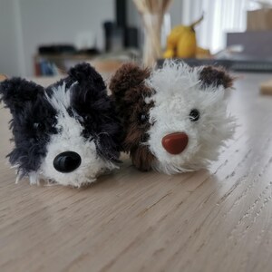 以下が含まれることがあります： 刺繍された顔とボタンの目をつけた、黒と白のぬいぐるみ犬と茶色と白のぬいぐるみ犬の2匹