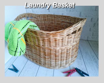 May include: A natural woven wicker laundry basket with a green and white striped towel inside.
