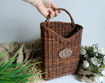 Wicker hanging STORM DOOR basket in a rustic style, featuring a broun color, displaying enhancing cottage wall, door decor